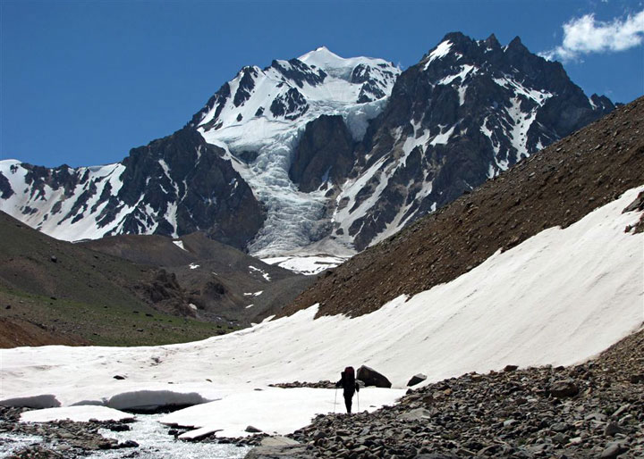 Vista de la Cara Sureste de los Gemelos desde el Arroyo de los Gemelos a unos 3.450 mts. El glaciar, "Glaciar Sureste o del Vasco", desciende tal vez por debajo de los 3.600 mts. Nuestra ruta de subida en el 2002 ascendio directamente por la cascada de hielo, luego a la derecha hacia una olla glaciar alta donde hicimos campamento y luego directamente a la cumbre del Gemelo Este (5.117 mts). El Portezuelo de los Gemelos por donde pasamos el dia 3 es el collado a la izquierda del cerro, donde hay una cornisa de nieve. Travesía alredor de Los Gemelos, Mendoza